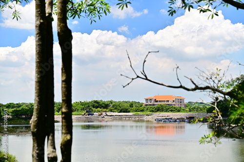 On a summer day under a blue sky and white clouds, the lake and mountain scenery of Hutoupi Scenic Area in Tainan showcases Taiwan's natural beauty. photo