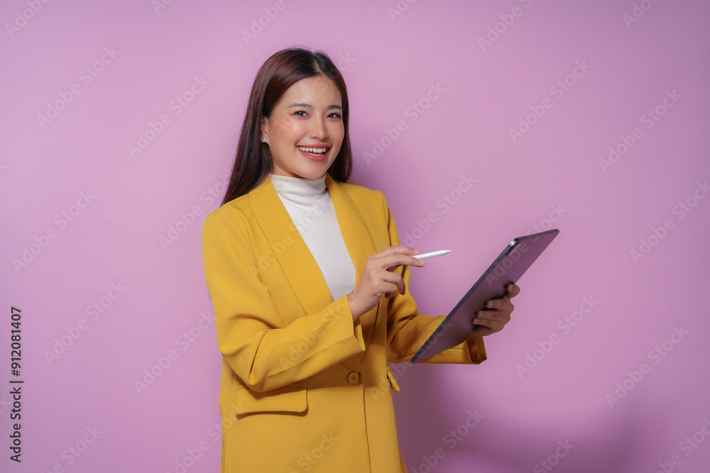 Smiling businesswoman using digital tablet and stylus, standing on purple background Smiling businesswoman using digital tablet and stylus, standing on purple background