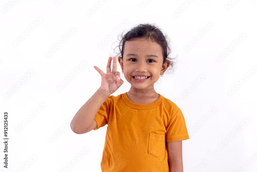 A little Asian girl smiling and making an OK or agree gesture with her hand on a white background A little Asian girl smiling and making an OK or agree gesture with her hand on a white background