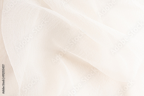 delicate soft folds of chiffon, silk, transparent fabric in champagne, ivory, beige as a wedding background with a copy space