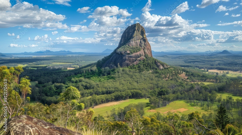 Fototapeta premium Majestic Mountain Peak Rising Above Lush Green Valley - A breathtaking view of a solitary mountain peak, its rugged slopes contrasting with the vibrant green valley below, symbolizing strength, resili
