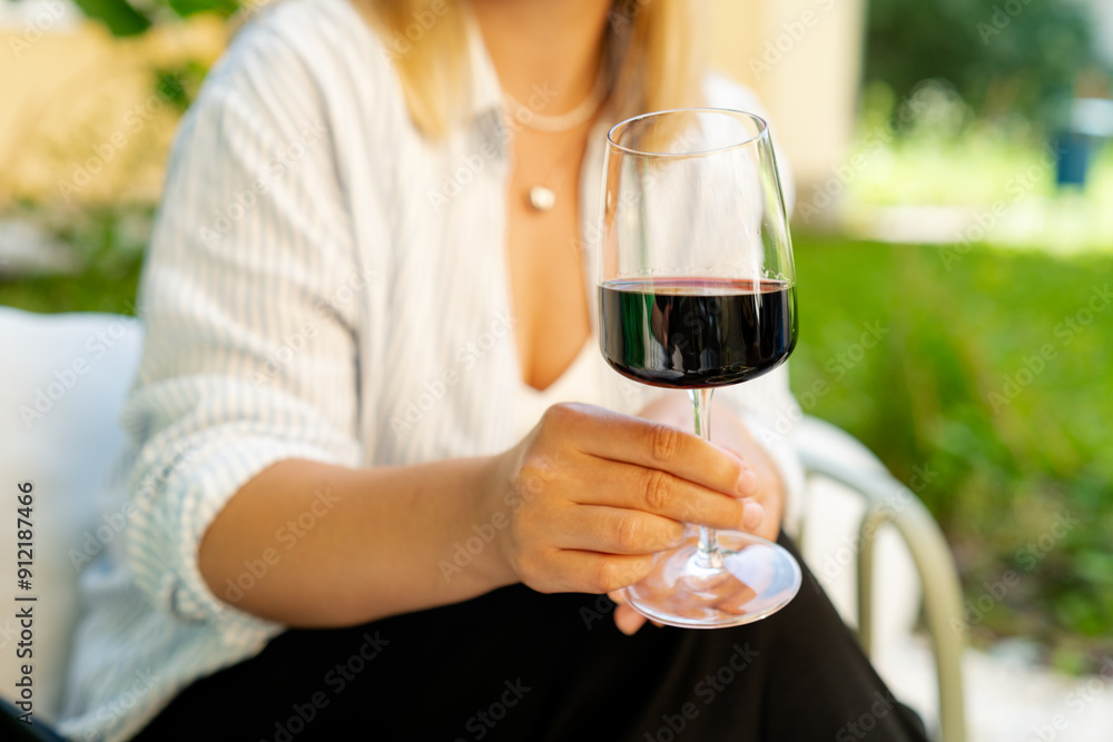 Close-up of a woman raising a glass of red wine Close-up of a woman raising a glass of red wine