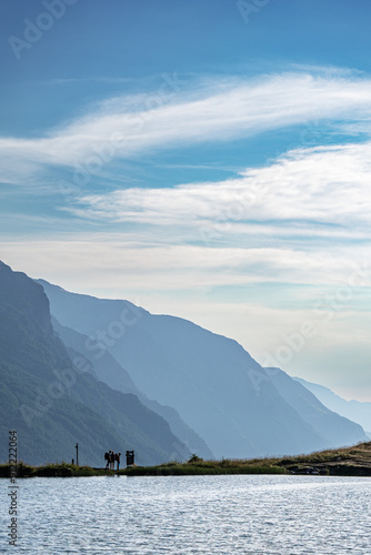 A group of hikers studying a sigh at the lake in the Alps