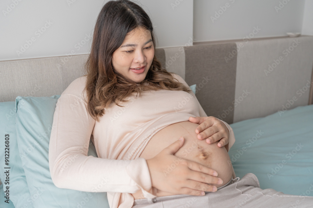 Pregnant asian woman holds hands on belly touching her baby caring about her health Beautiful happy pregnant woman tender mood photo of pregnancy Pregnant asian woman holds hands on belly touching her baby caring about her health Beautiful happy pregnant woman tender mood photo of pregnancy