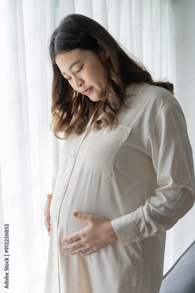 Pregnant asian woman holds hands on belly touching her baby caring about her health Beautiful happy pregnant woman tender mood photo of pregnancy Pregnant asian woman holds hands on belly touching her baby caring about her health Beautiful happy pregnant woman tender mood photo of pregnancy