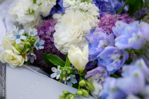 a beautiful freshly cut bouquet of mixed flowers. Bouquet of fresh hydrangeas, freesia, carnations, Allium Flowers in blue and pastel colors