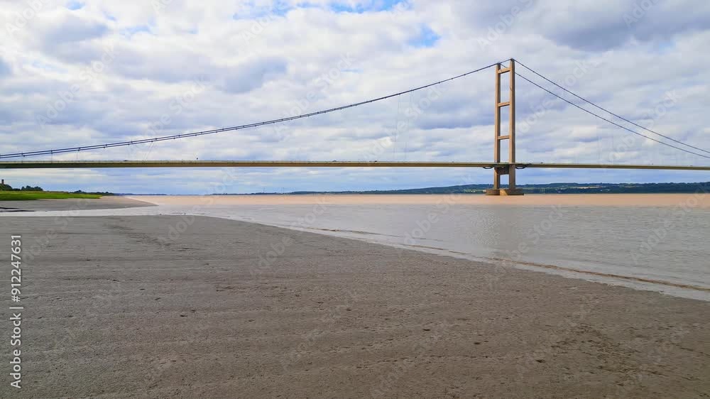 Aerial drone view of Humber Bridge, 12th largest suspension span, gracefully crossing River Humber, connecting Lincolnshire to Humberside with traffic. Aerial drone view of Humber Bridge, 12th largest suspension span, gracefully crossing River Humber, connecting Lincolnshire to Humberside with traffic.