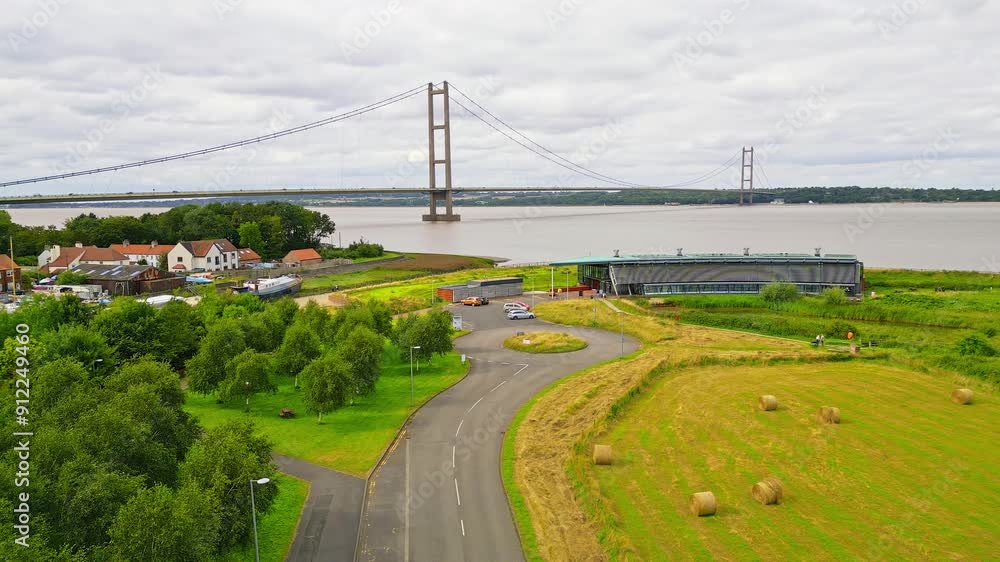 Aerial drone view of Humber Bridge, 12th largest suspension span, gracefully crossing River Humber, connecting Lincolnshire to Humberside with traffic. Aerial drone view of Humber Bridge, 12th largest suspension span, gracefully crossing River Humber, connecting Lincolnshire to Humberside with traffic.