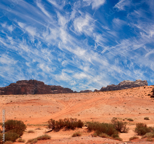 Wadi Rum Desert also known as The Valley of the Moon (against the sky with clouds)-- is a valley cut into the sandstone and granite rock in southern Jordan 60 km to the east of Aqaba