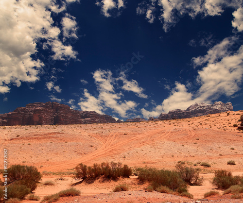 Wadi Rum Desert also known as The Valley of the Moon (against the sky with clouds)-- is a valley cut into the sandstone and granite rock in southern Jordan 60 km to the east of Aqaba