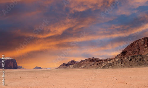 Wadi Rum Desert also known as The Valley of the Moon (against the sky with clouds)-- is a valley cut into the sandstone and granite rock in southern Jordan 60 km to the east of Aqaba