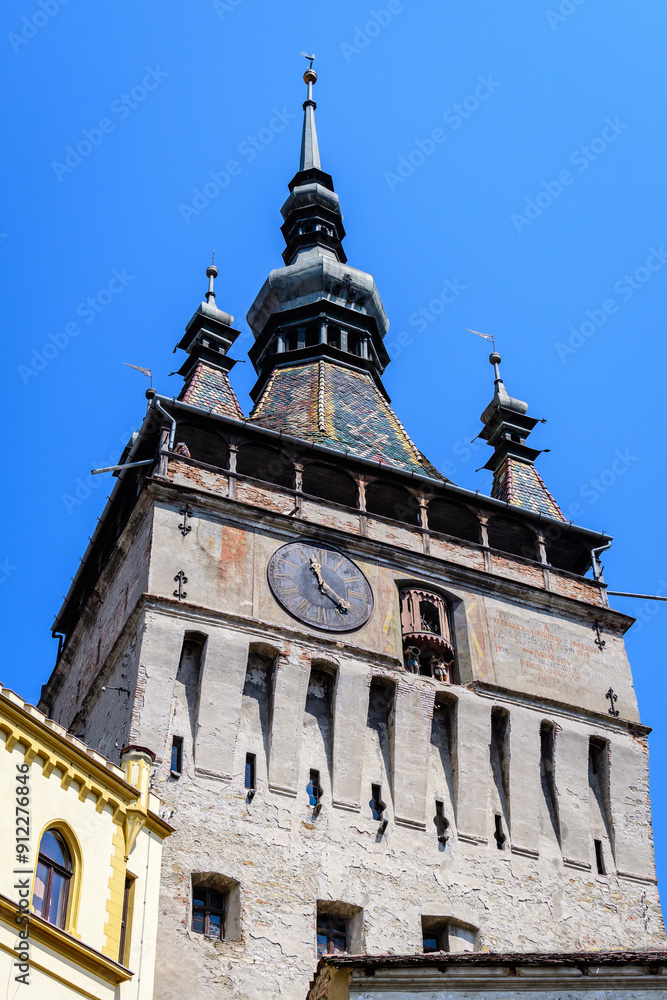 The The Clock Tower or the Council Tower of the medieval citadel in the old center of Sighisoara, a UNESCO World Heritage Site in Transylvania (Transilvania) region, Romania, in a sunny summer day. The The Clock Tower or the Council Tower of the medieval citadel in the old center of Sighisoara, a UNESCO World Heritage Site in Transylvania (Transilvania) region, Romania, in a sunny summer day.