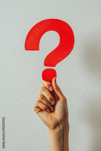 hand holding up a big red question mark made of paper isolated on clean smooth solid background