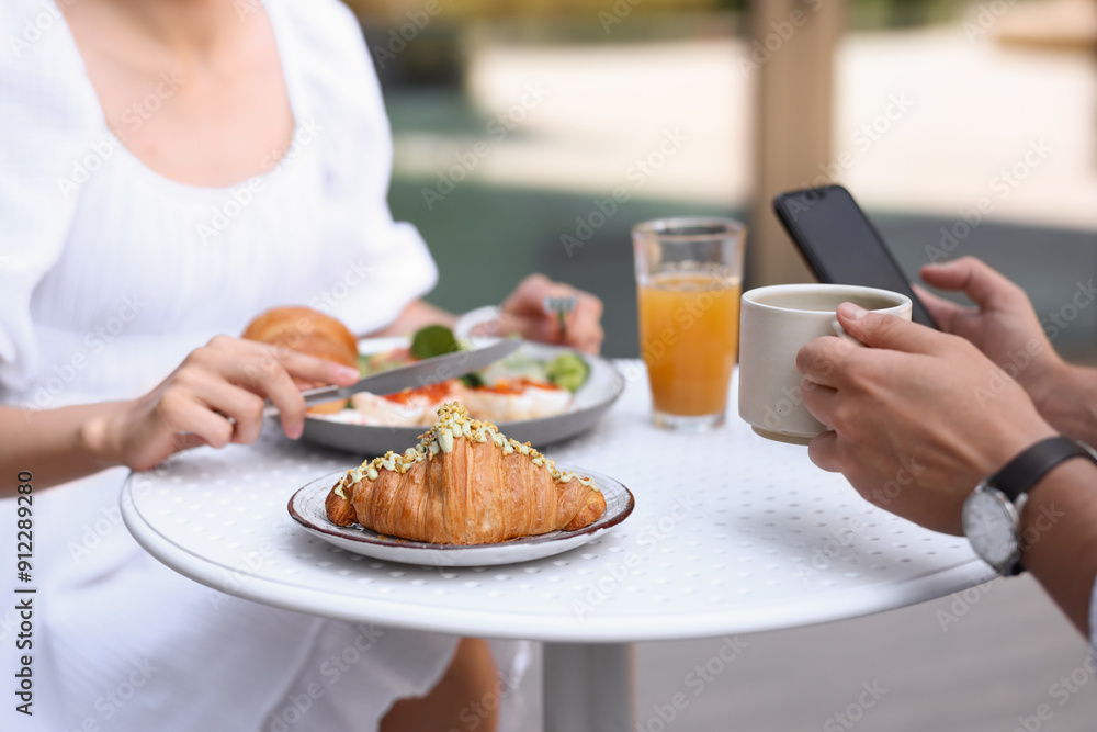 Couple having tasty breakfast in outdoor cafe, closeup Couple having tasty breakfast in outdoor cafe, closeup