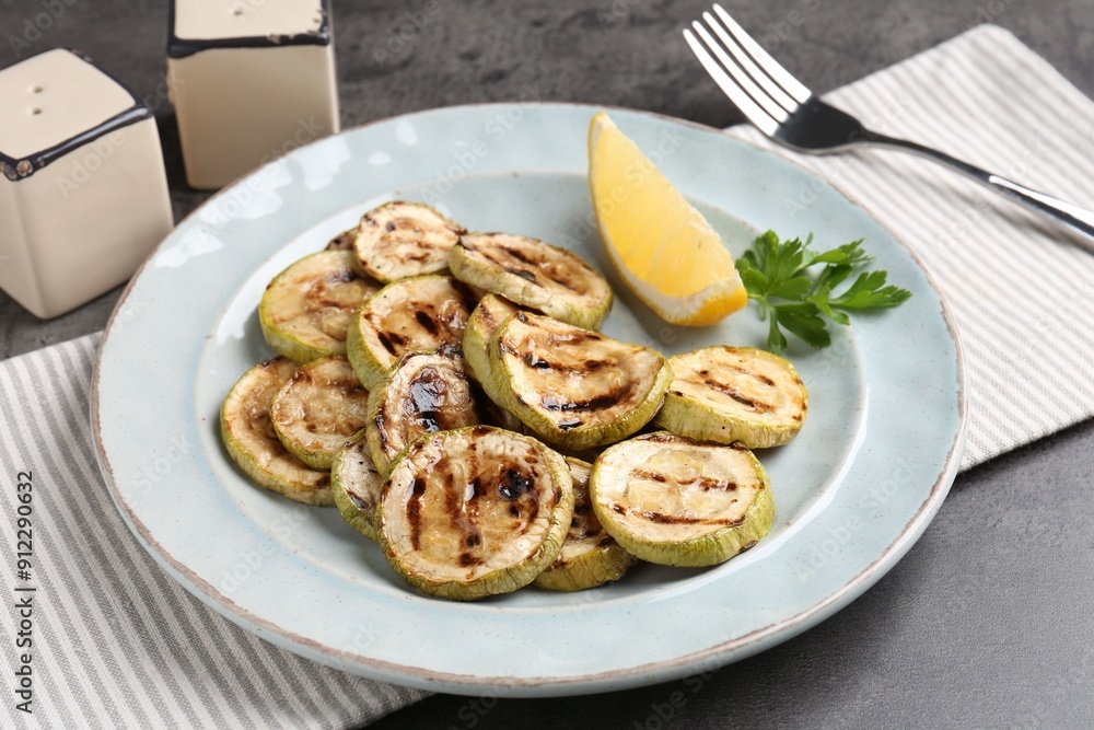 Tasty grilled zucchini slices served on grey table Tasty grilled zucchini slices served on grey table