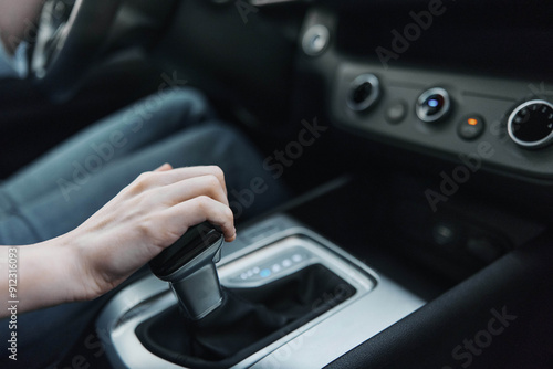 Car, driver, automatic gearbox, shift knob, steering wheel a person is driving a car, adjusting the automatic gearbox using the shift knob located on the steering wheel for better control