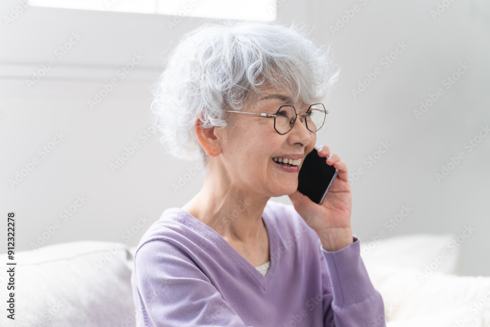 スマートフォンで通話しているシニア女性 スマートフォンで通話しているシニア女性