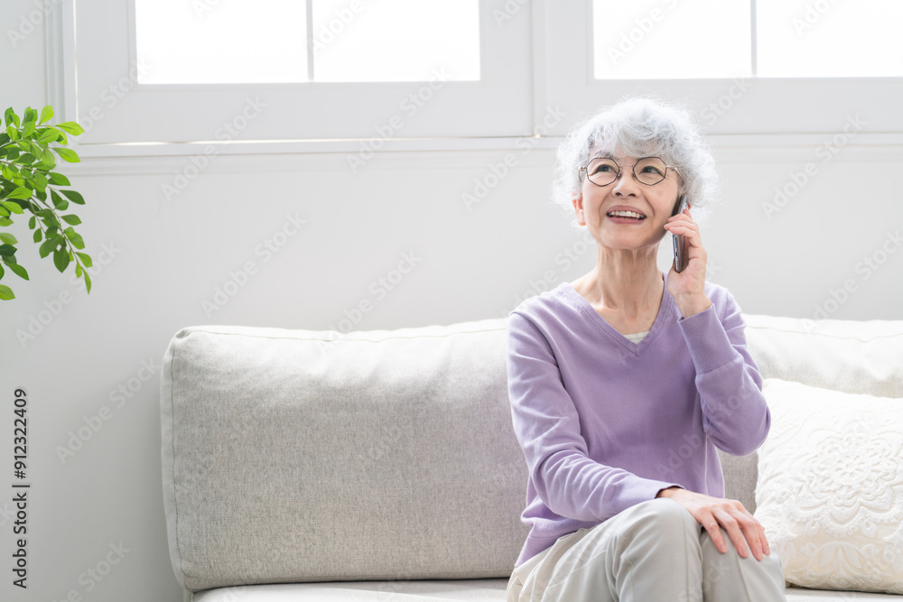 スマートフォンで通話しているシニア女性