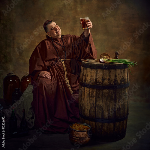 Photos Medieval monk, man lifting pint of ale against dark vintage background