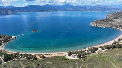 Aerial drone video of paradise scenic round sandy beach of Karathonas next to historic city of Nafplio, Argolida, Greece photo