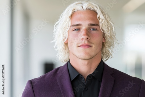 Handsome young man with wavy blonde hair wearing a purple suit