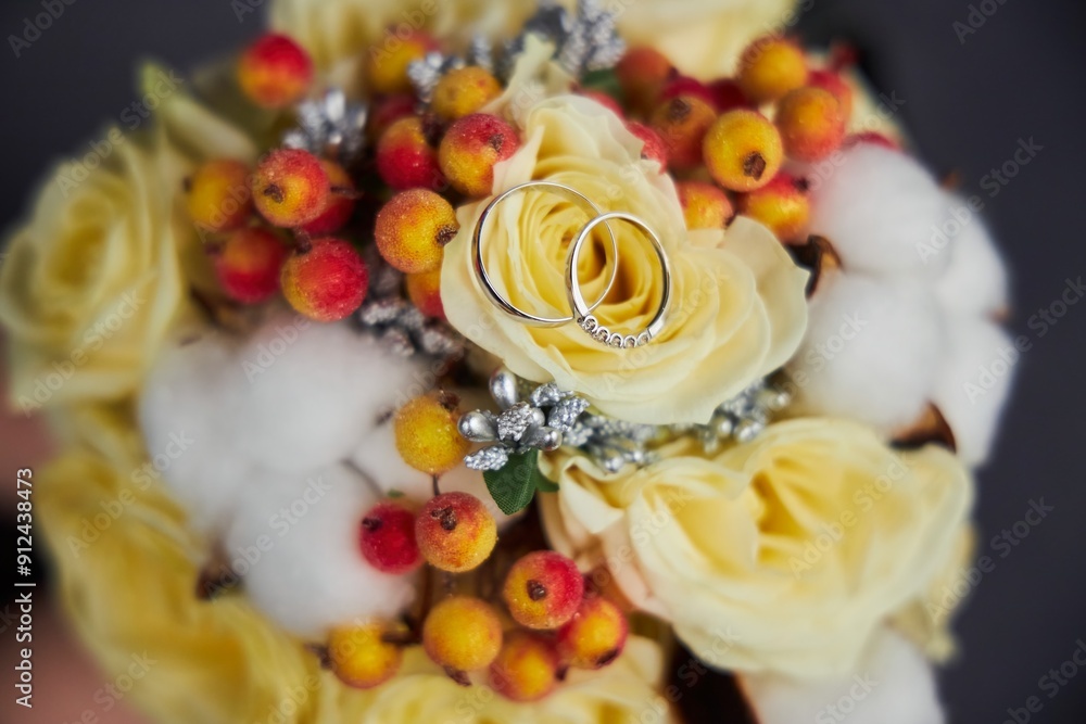 A bouquet of yellow flowers with a ring on top of each flower. The rings are silver and have diamonds on them. A bouquet of yellow flowers with a ring on top of each flower. The rings are silver and have diamonds on them.