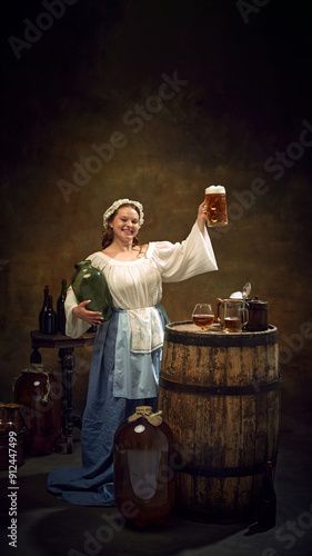фотографія Woman brewer, dressed old-fashion clothes, holding high fresh-cooked, frothy glass of beer at ancient pub against vintage background