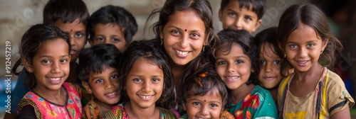 A group of children are smiling and posing for a picture. The woman in the center is smiling and looking at the camera. The children are all dressed in colorful clothing