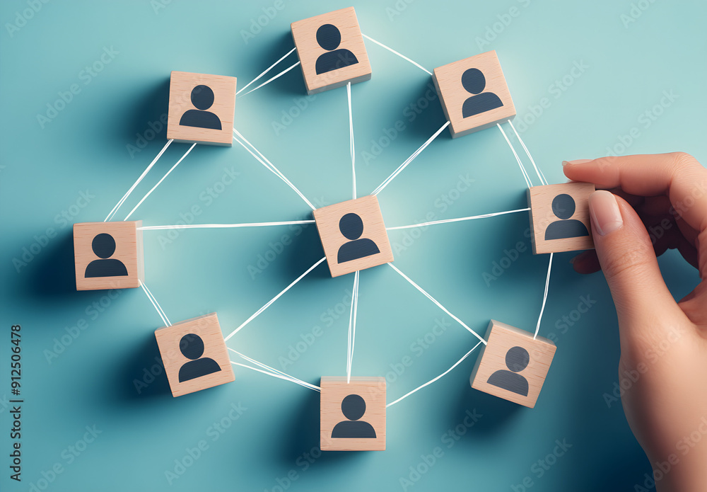 A Hand Connecting Wooden Blocks with Human Icon Figures Symbolizing Team Building and Collaboration A Hand Connecting Wooden Blocks with Human Icon Figures Symbolizing Team Building and Collaboration