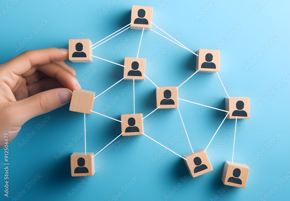 A Hand Connecting Wooden Blocks with Human Icon Figures Symbolizing Team Building and Collaboration A Hand Connecting Wooden Blocks with Human Icon Figures Symbolizing Team Building and Collaboration