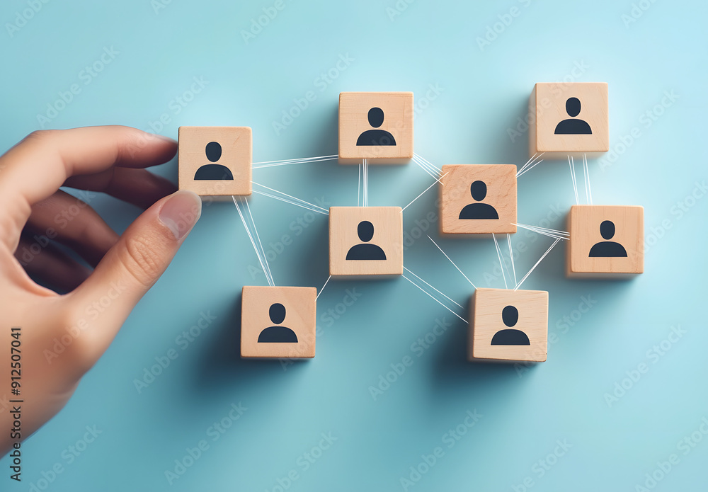 A Hand Connecting Wooden Blocks with Human Icon Figures Symbolizing Team Building and Collaboration A Hand Connecting Wooden Blocks with Human Icon Figures Symbolizing Team Building and Collaboration