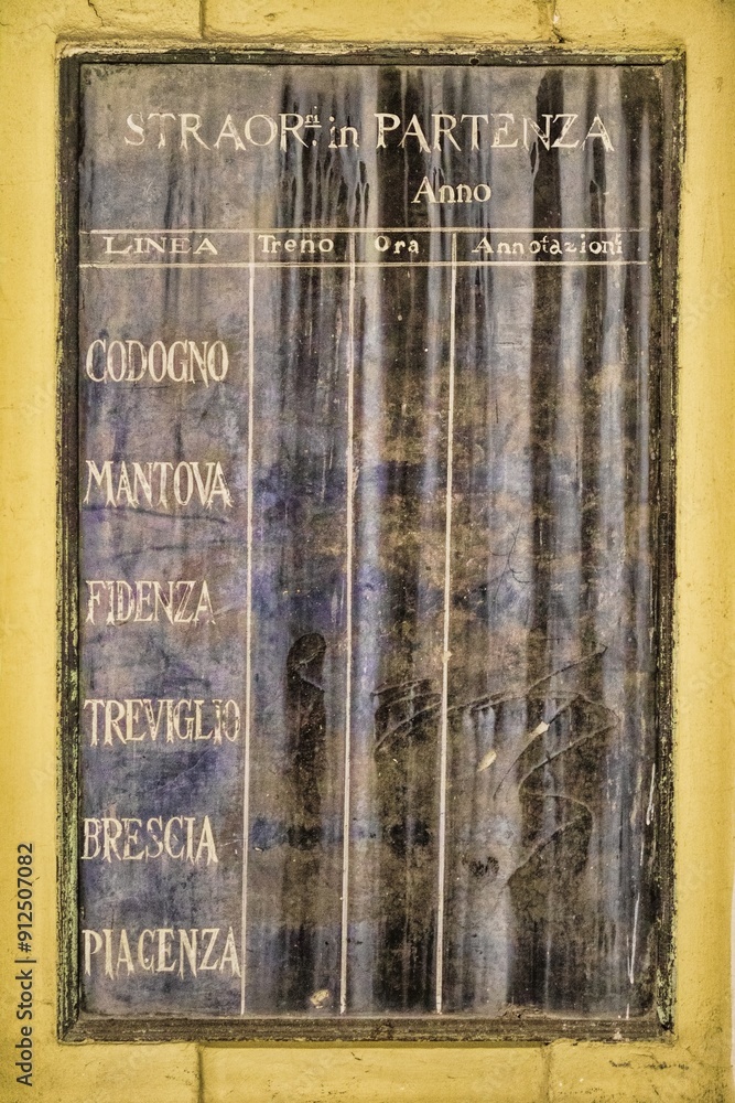 cremona, italien - verwitterter fahrplan am bahnhof