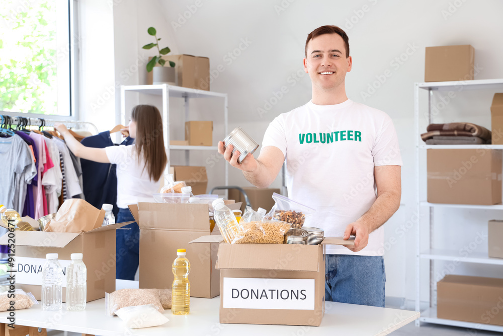 Male volunteer with food donations in center Male volunteer with food donations in center