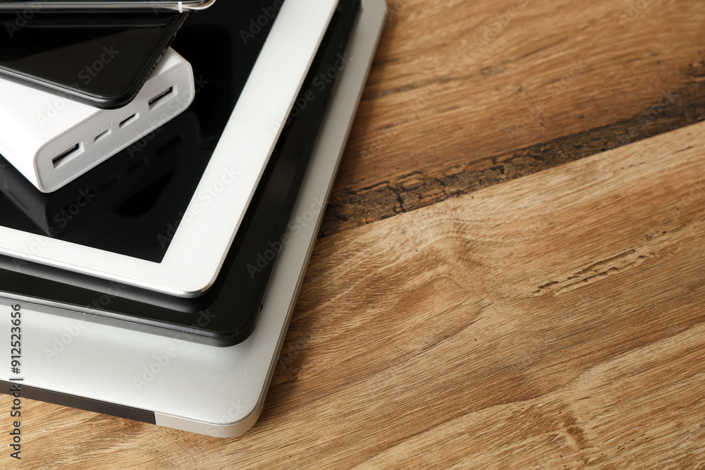 Stack of modern gadgets on wooden table, closeup Stack of modern gadgets on wooden table, closeup