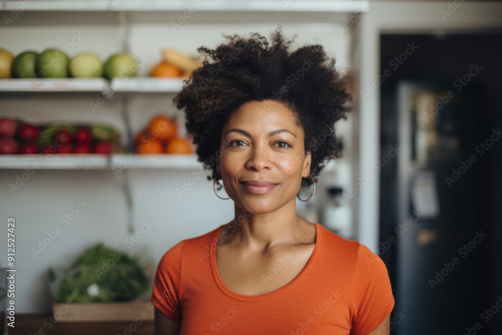 Portrait of a African American middle aged fit woman in kitchen with vegetables Portrait of a African American middle aged fit woman in kitchen with vegetables