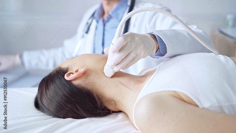 Naklejka premium Doctor man is using ultrasound equipment on neck of female patient lying down for a medical examination. Medicine and science