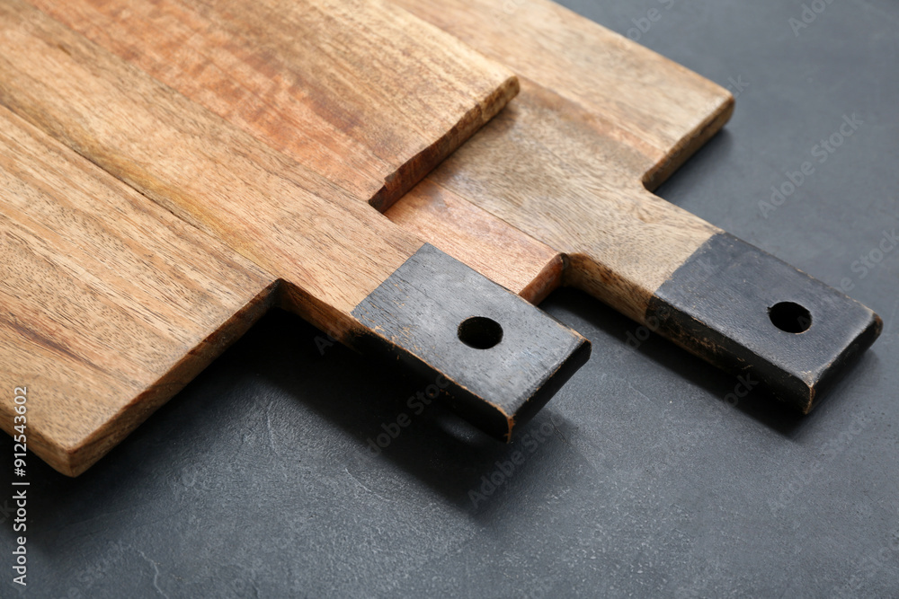 Wooden cutting boards on black background, closeup Wooden cutting boards on black background, closeup