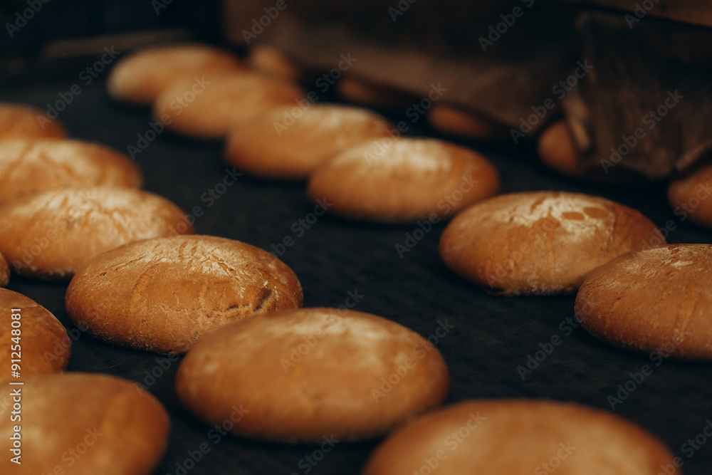 Fresh buns from the oven. Conveyor with bread. Baking bread. Workshop for production of bread. White bread in the oven. Hot buns. Confectionery. Fresh buns from the oven. Conveyor with bread. Baking bread. Workshop for production of bread. White bread in the oven. Hot buns. Confectionery.