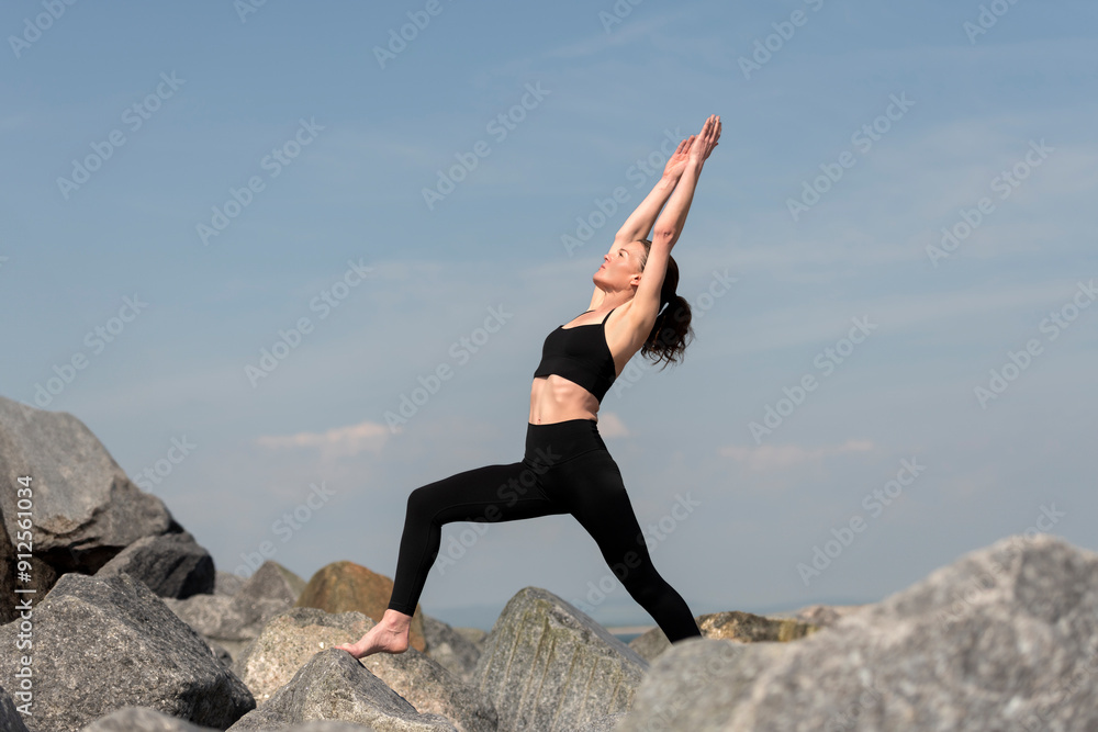 woman doing a yoga high lunge pose, outdoors with rocky background woman doing a yoga high lunge pose, outdoors with rocky background