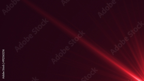 Red spotlight on a dark background with bright beams of light.