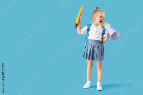 Cute little schoolgirl with big pencil and megaphone on blue background
