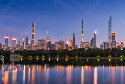 New York City skyline at dusk with reflections of Billionaires Row supertall skyscrapers in Central Park Reservoir. Evening view of illuminated luxury towers in Midtown Manhattan photo