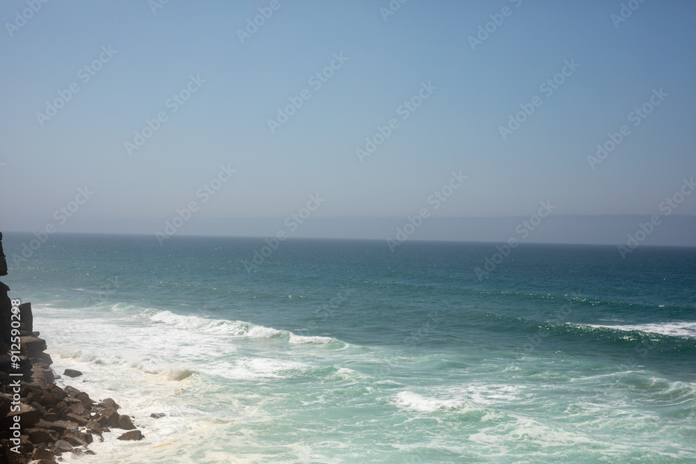 The vast ocean stretches out before a rocky cliff a glimpse of the power and beauty of nature The vast ocean stretches out before a rocky cliff a glimpse of the power and beauty of nature
