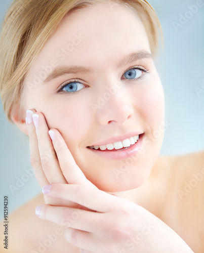 Portrait, relax and happy woman in studio for beauty or treatment for facial glow, shine or wellness. Dermatology, hands or girl with face routine for cosmetics or natural skincare by blue background