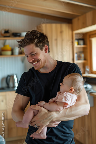 A happy father holding his child in his arms, love in the family, fatherhood of a young man.