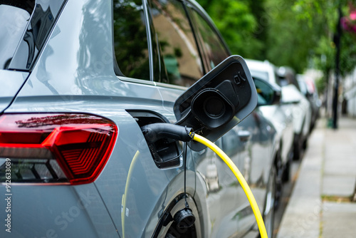An electric car plugged in on charge on a residential street in central London
