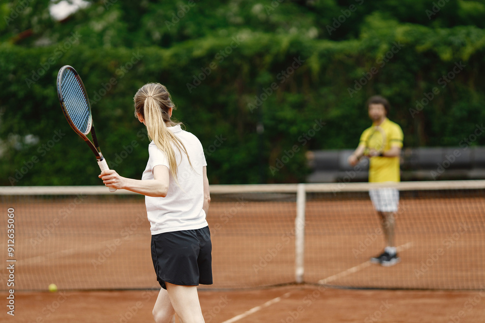 Fototapeta premium Tennis players playing a match on the court on a sunny day