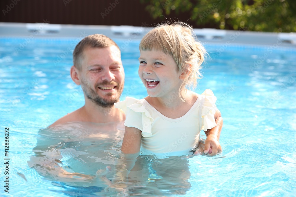 Fototapeta premium Happy father having fun with his daughter in swimming pool