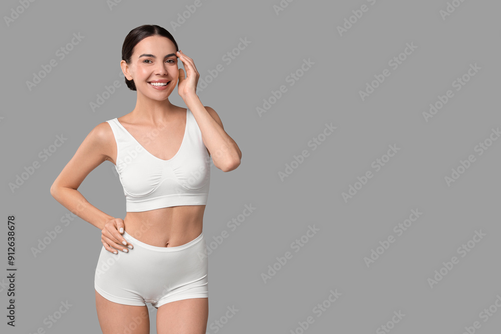 Smiling woman with perfect skin in underwear on grey background, space for text. Body care Smiling woman with perfect skin in underwear on grey background, space for text. Body care
