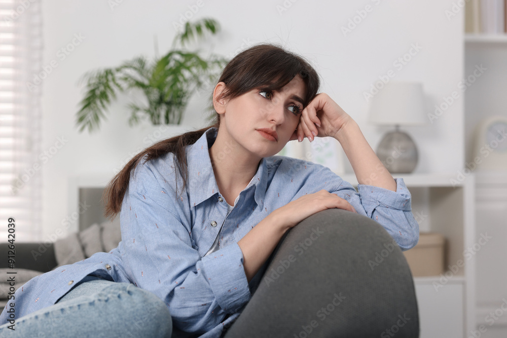 Loneliness concept. Sad woman sitting on sofa at home Loneliness concept. Sad woman sitting on sofa at home